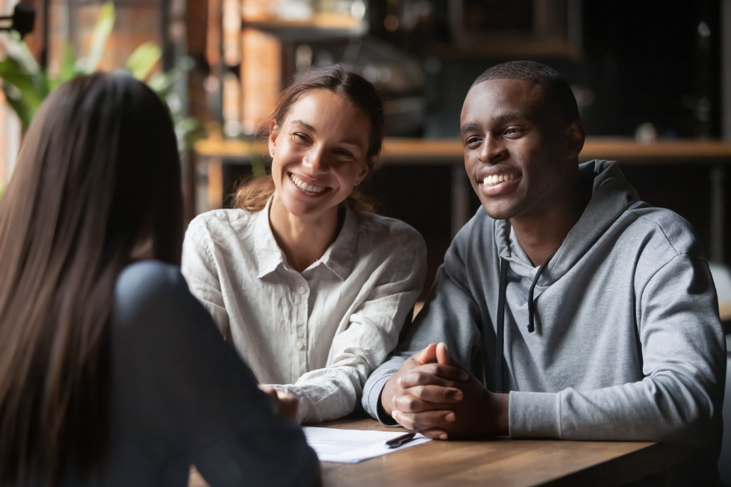 Smiling,Diverse,Couple,Listening,To,Financial,Advisor,Or,Realtor,At