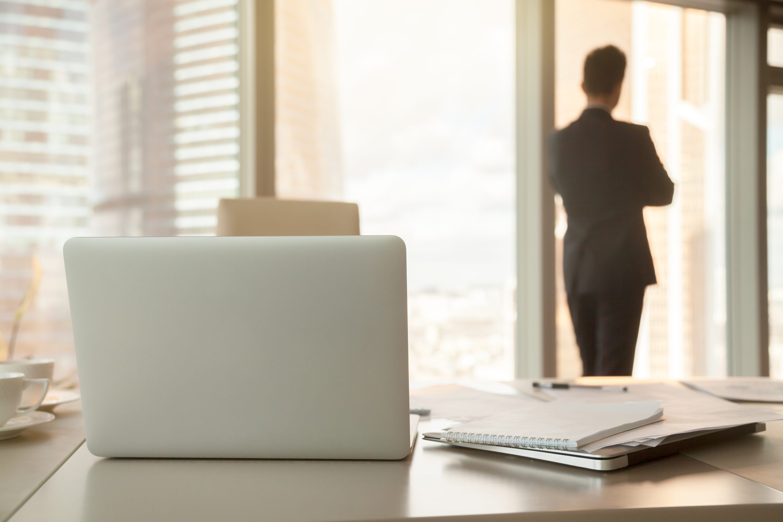 Back,View,Of,Workplace,,Focus,On,Office,Desk,With,Laptops