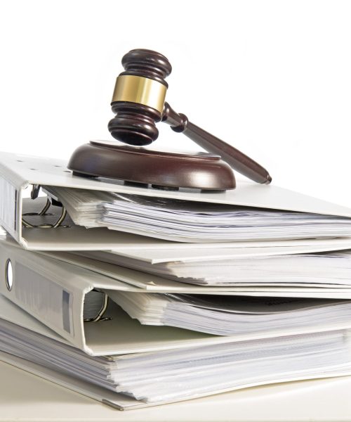 stack of folders and a judge gavel on a desk, isolated on a white background, concept for justice, business and finance, copy space, selected focus, narrow depth of field